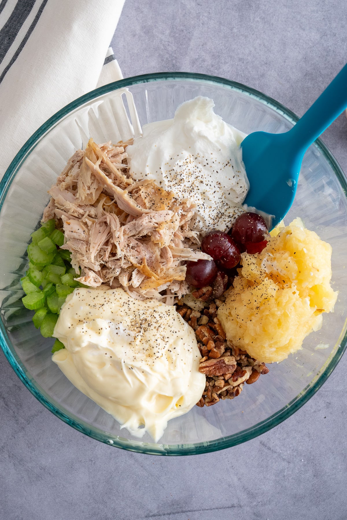 chicken salad ingredients separated in glass bowl