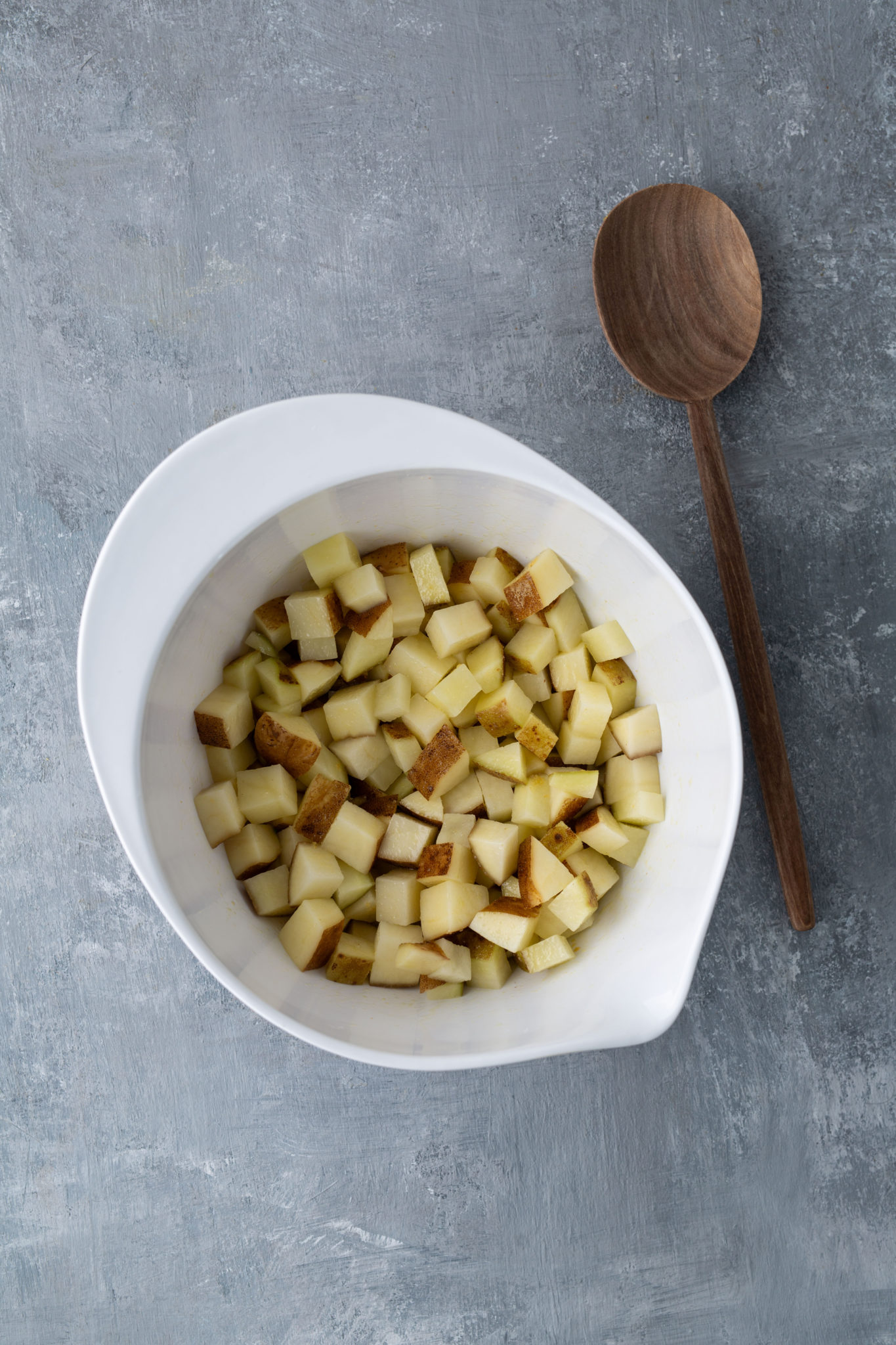 potatoes in bowl covered in seasoning