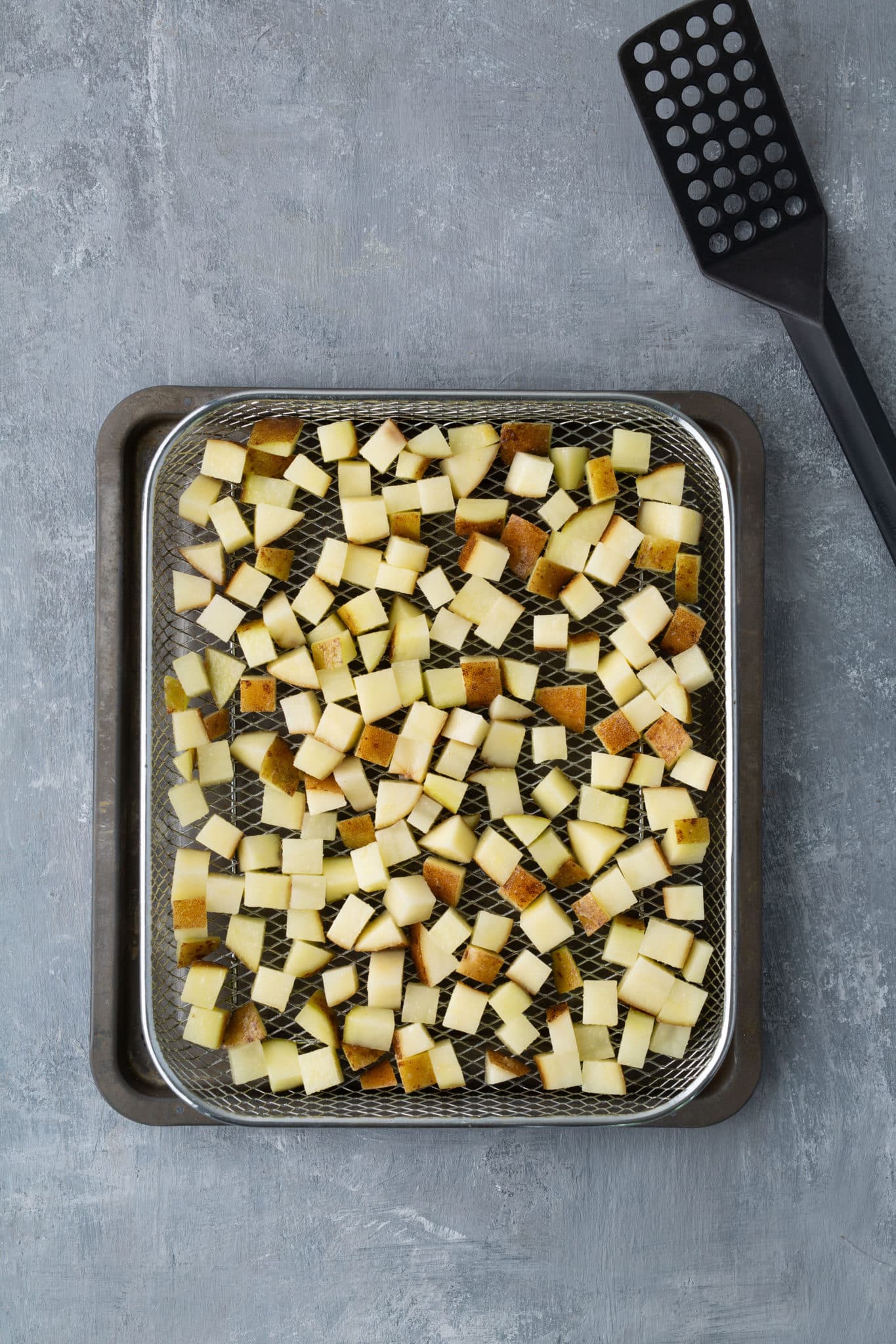 raw potatoes in air fryer tray