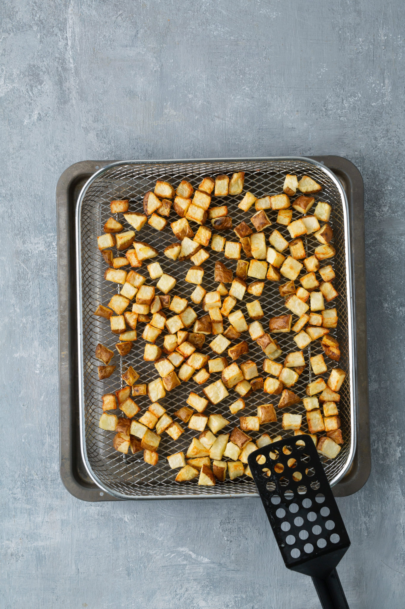 roasted air fryer potatoes on rack with spatula on the rack