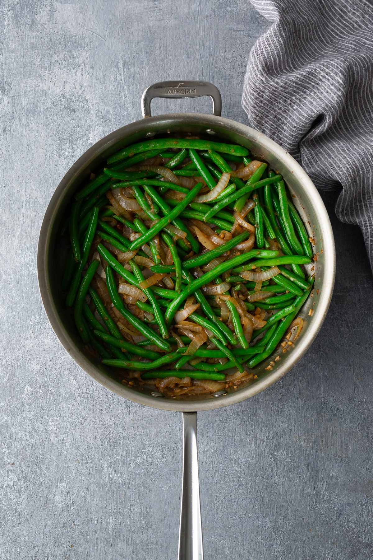 green beans and onions cooking in skillet