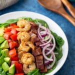 shrimp and bacon salad on plate with spoons on the side