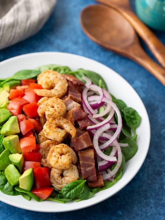 shrimp and bacon salad on plate with spoons on the side