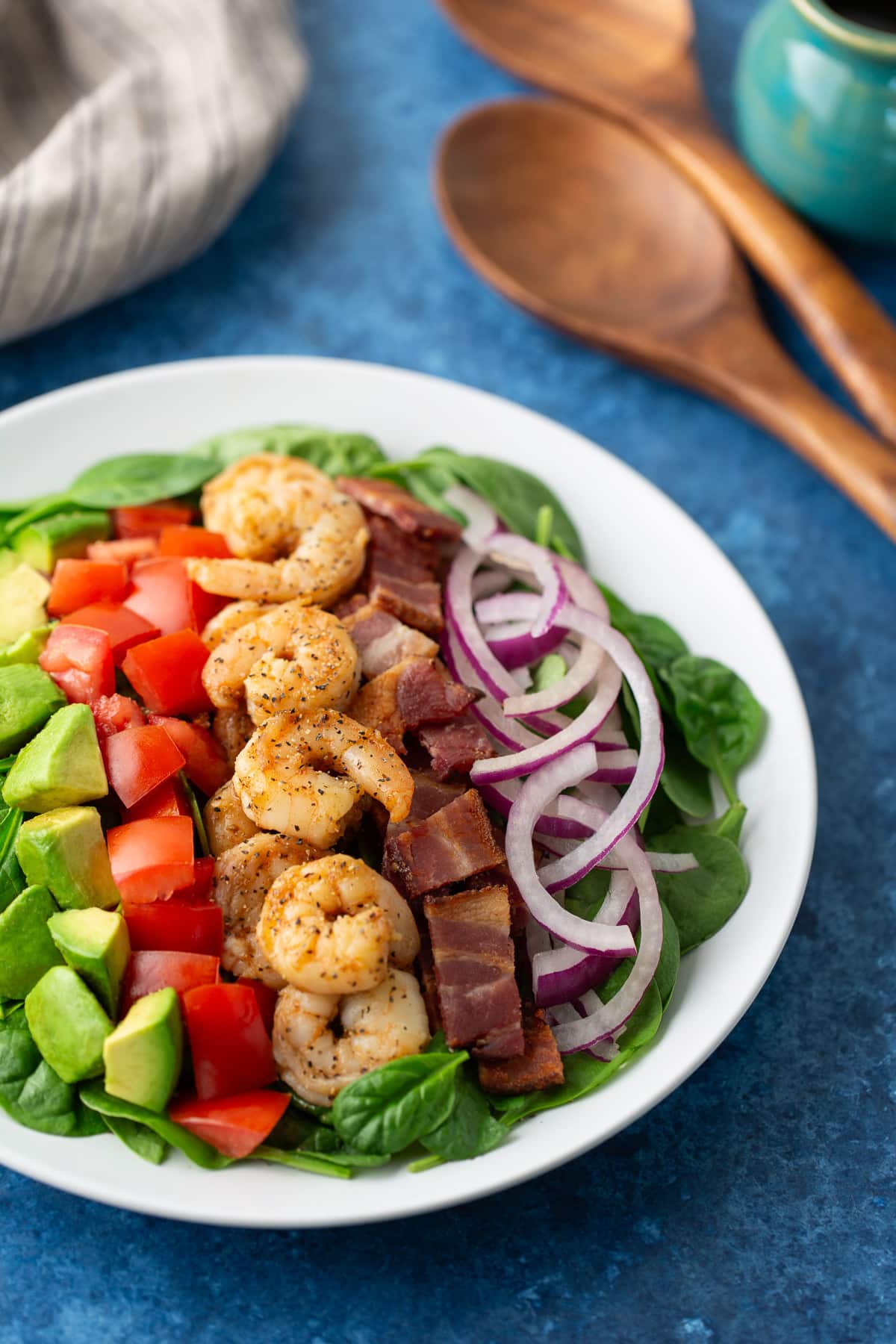 shrimp and bacon salad on plate with spoons on the side