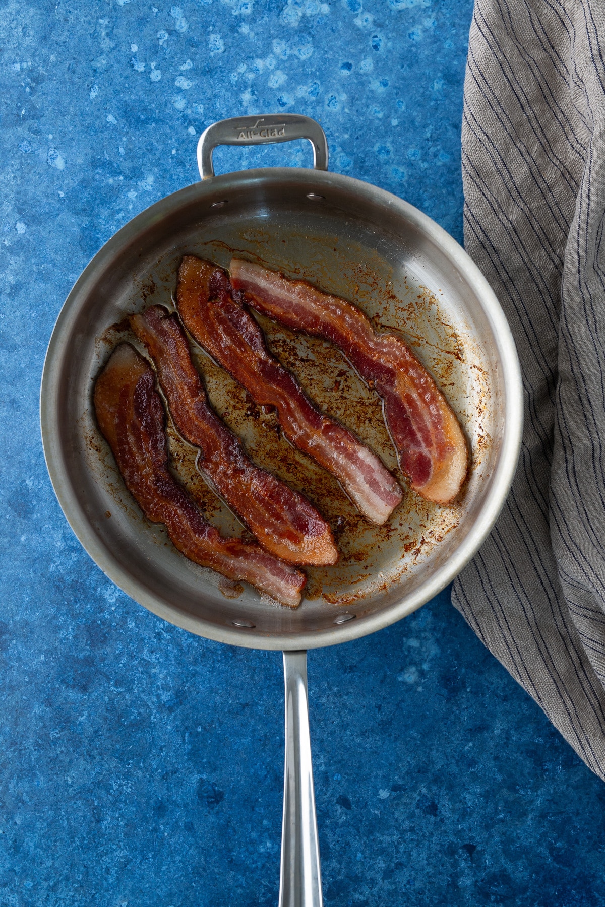 bacon being cooked in skillet