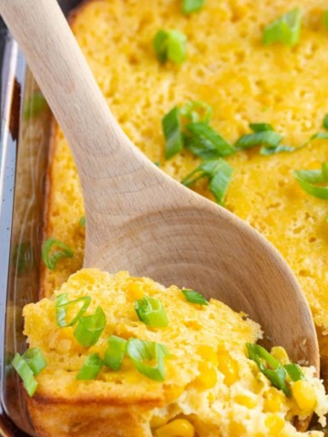 corn souffle in baking dish with spoon picking it up