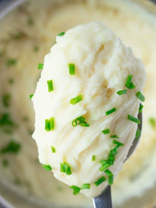 mashed potatoes on spoon with pressure cooker in background