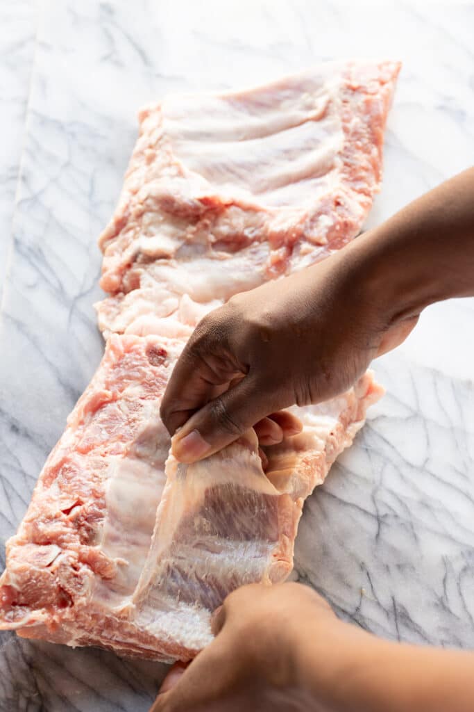 hand removing membrane from the back of ribs