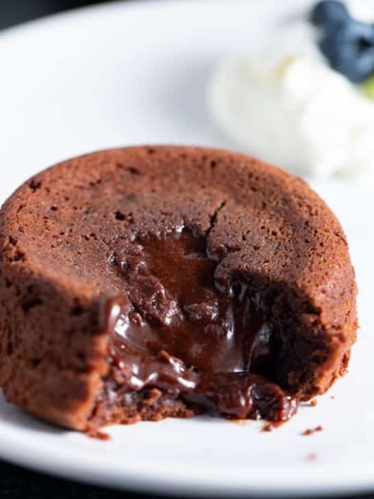 molten lava cake on white plate with blueberries in background