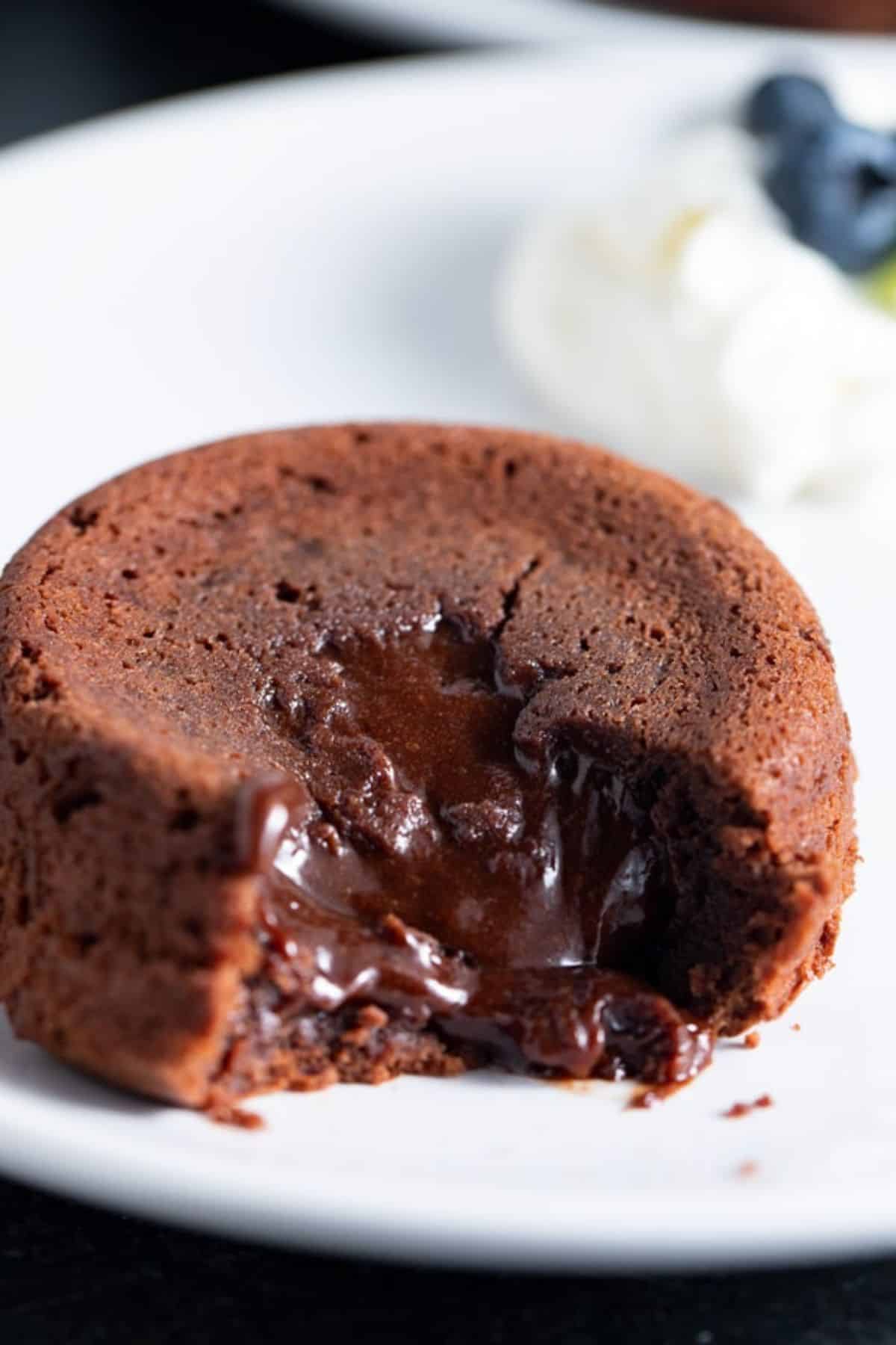 molten lava cake on white plate with blueberries in background