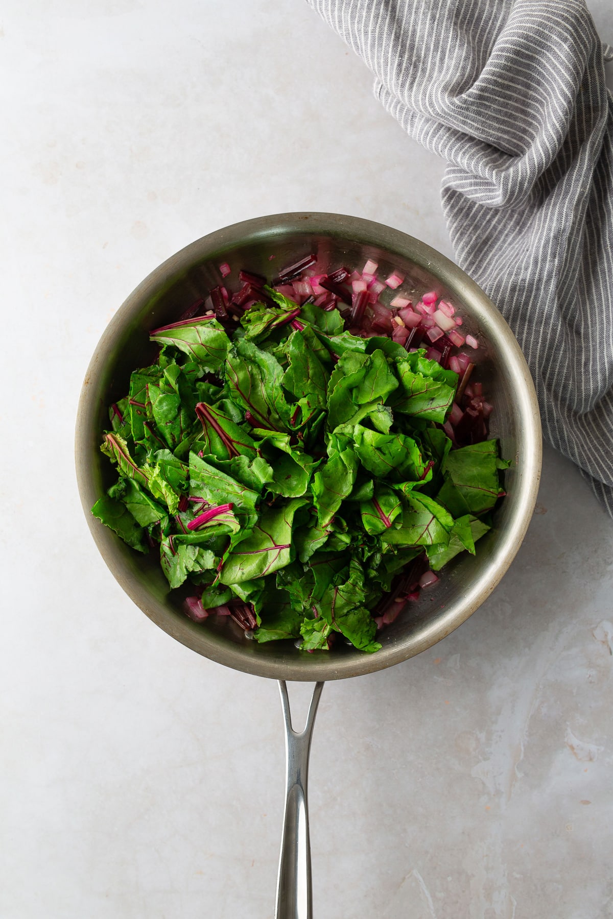 greens added to skillet with beet stems and onions