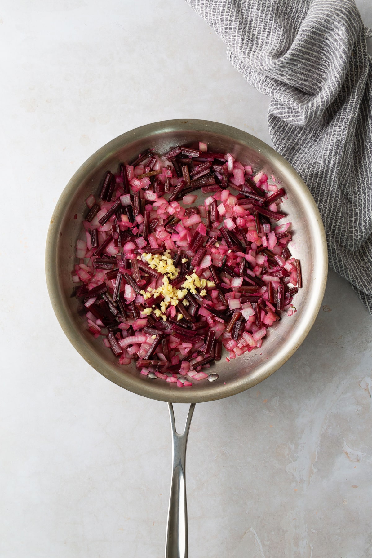 garlic added to skillet with onions and beet greens mixed