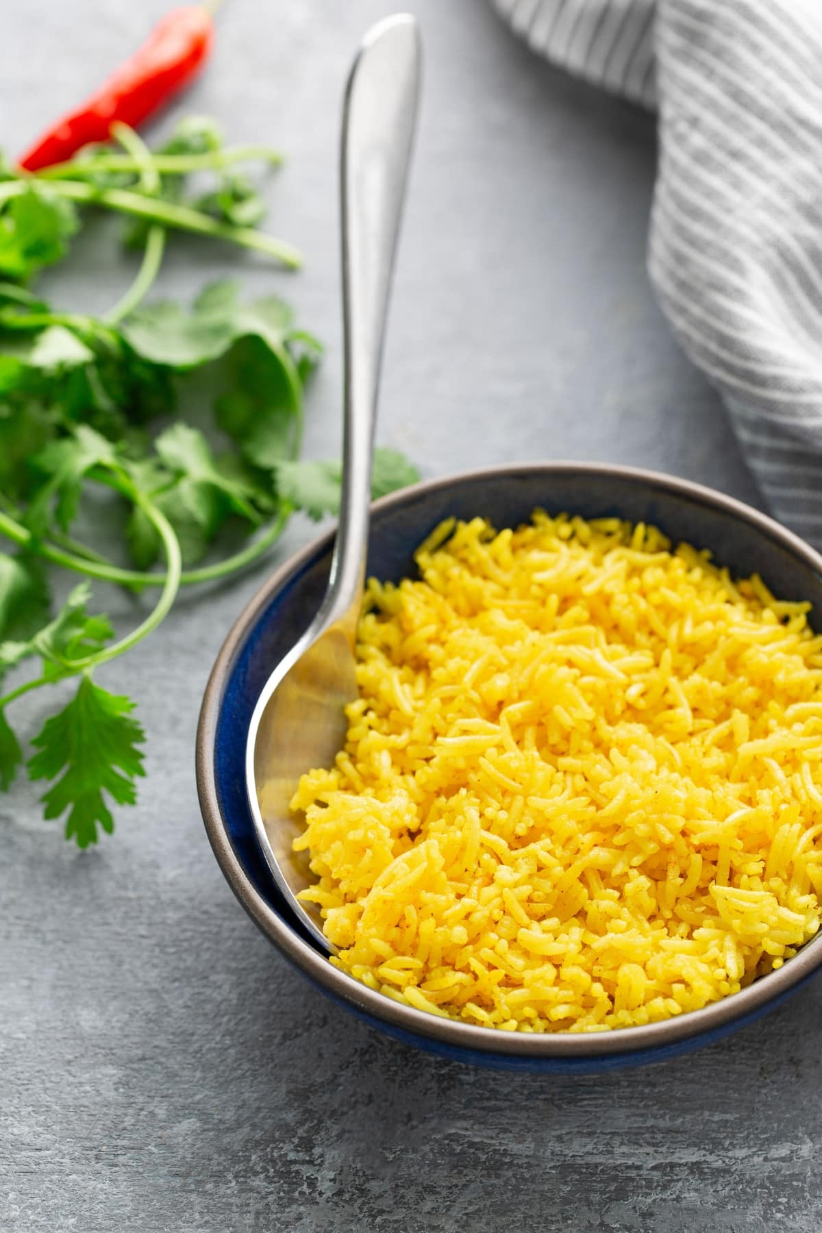 yellow rice in bowl wirh spoon sticking out