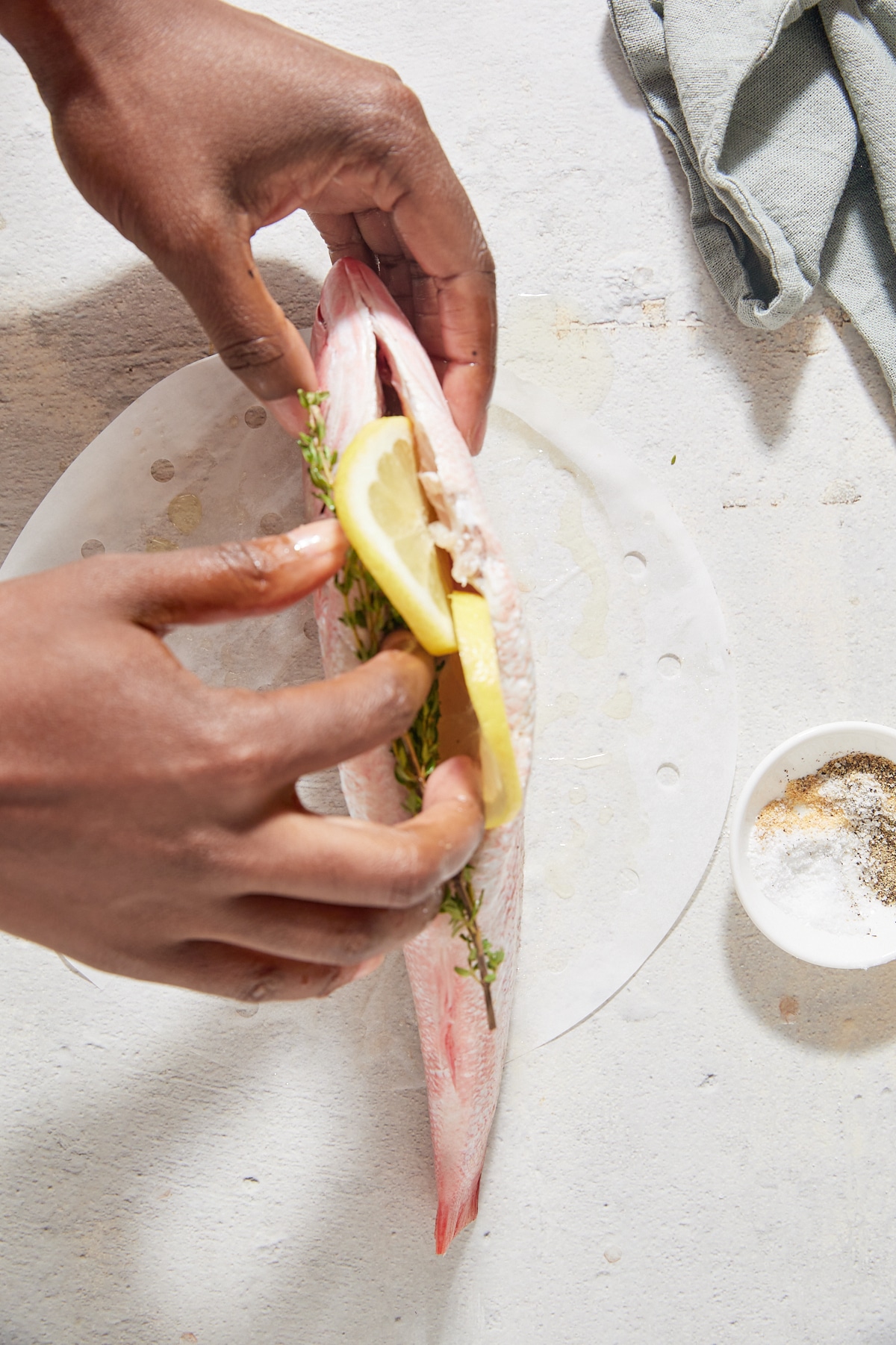 Stiffing the fish with lemon slices.