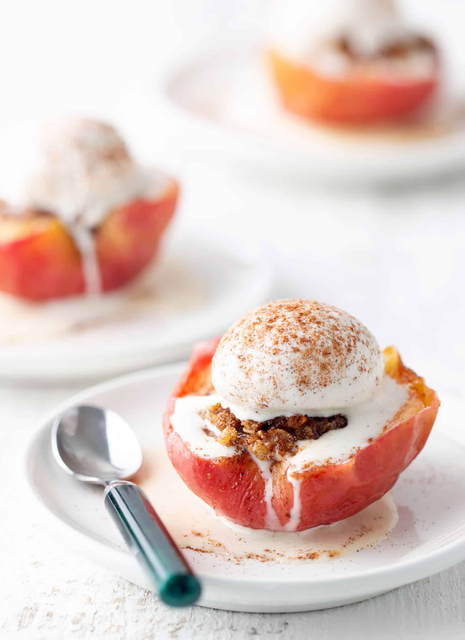 air fryer baked apples on white plate with spoon on side