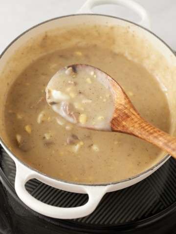 Stirring the giblet gravy with a spoon.