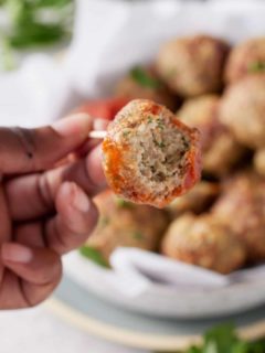 a turkey meatball with a bite taken out of it on a fork