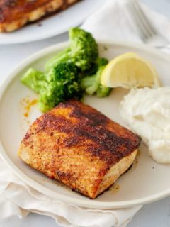 blackened mahi mahi on a plate with broccoli an mashed potatoes