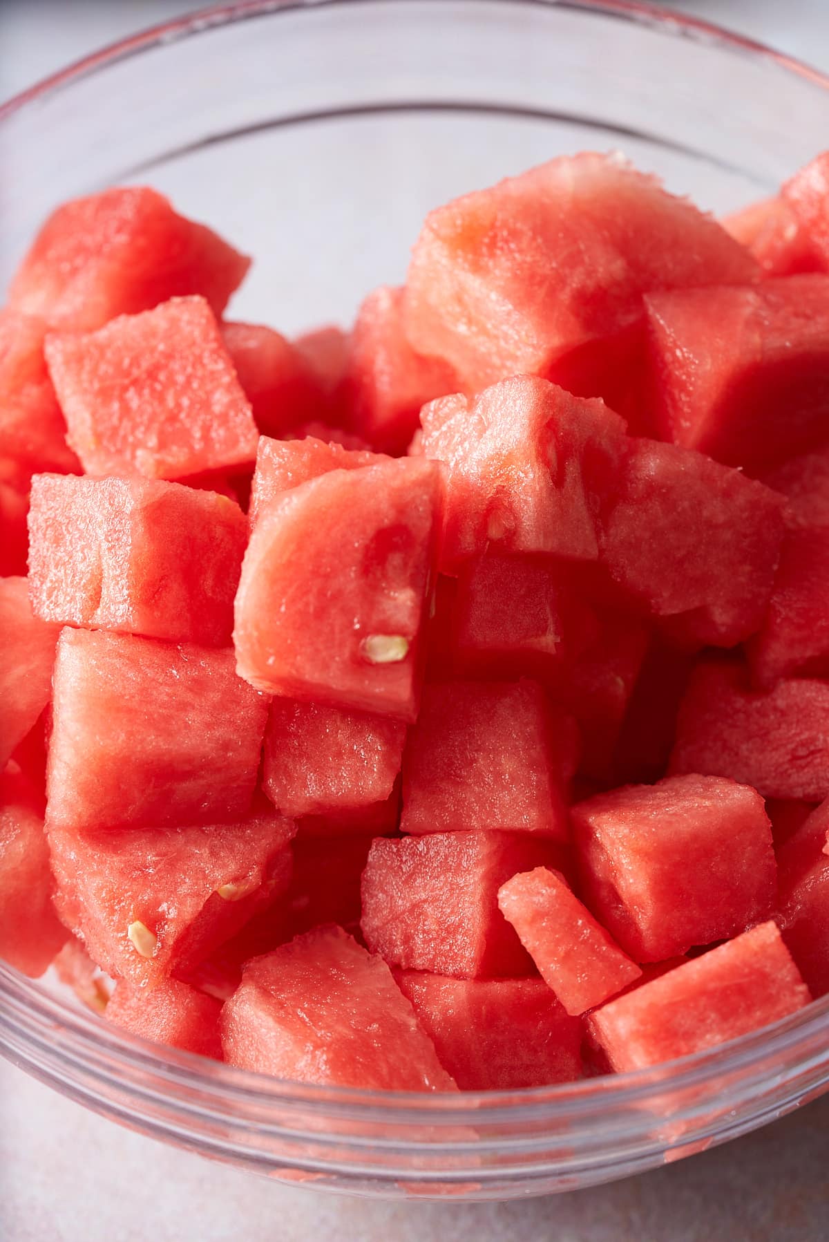 A glass bowl filled with diced watermelon.