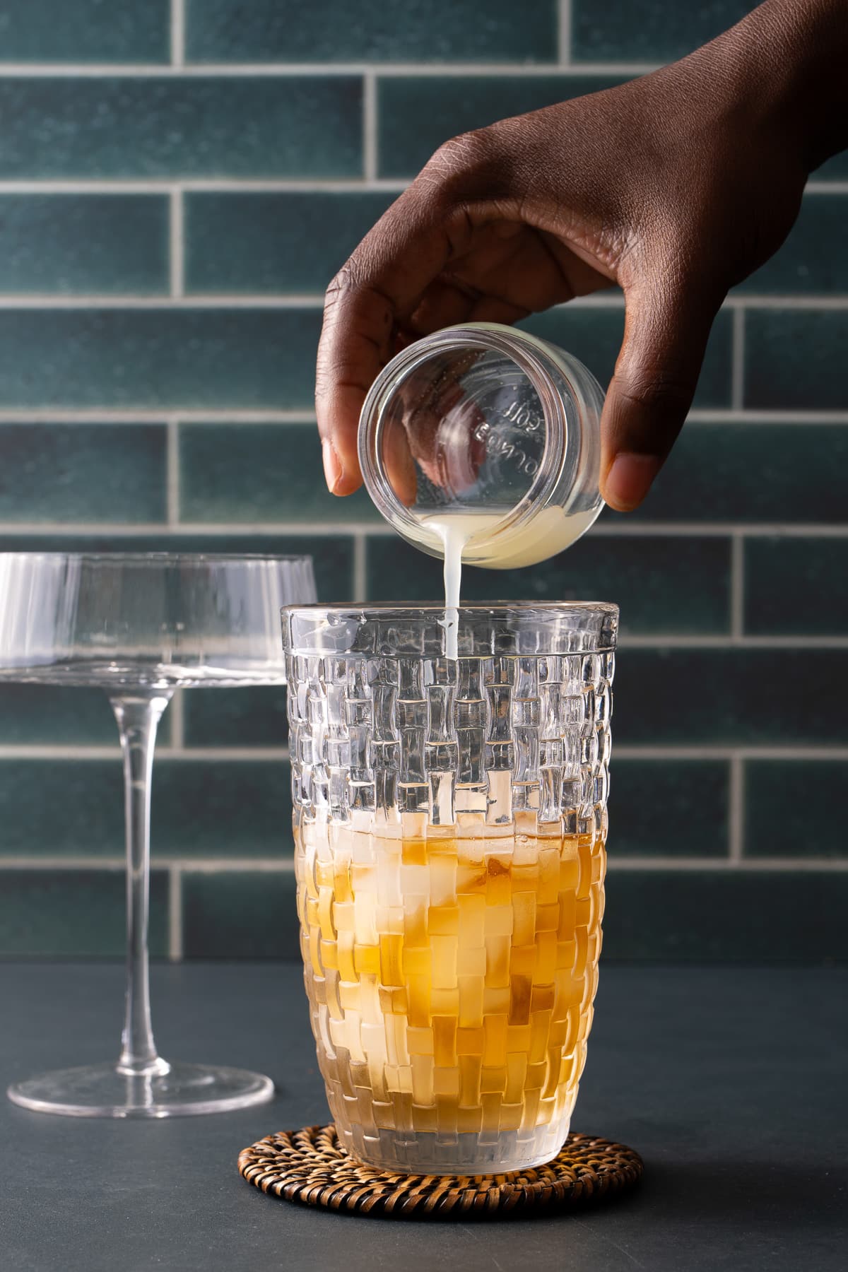 lemon juice being poured into cocktail shaker