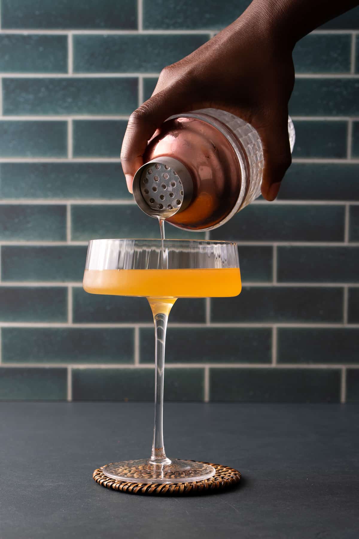 cocktail being poured into glass