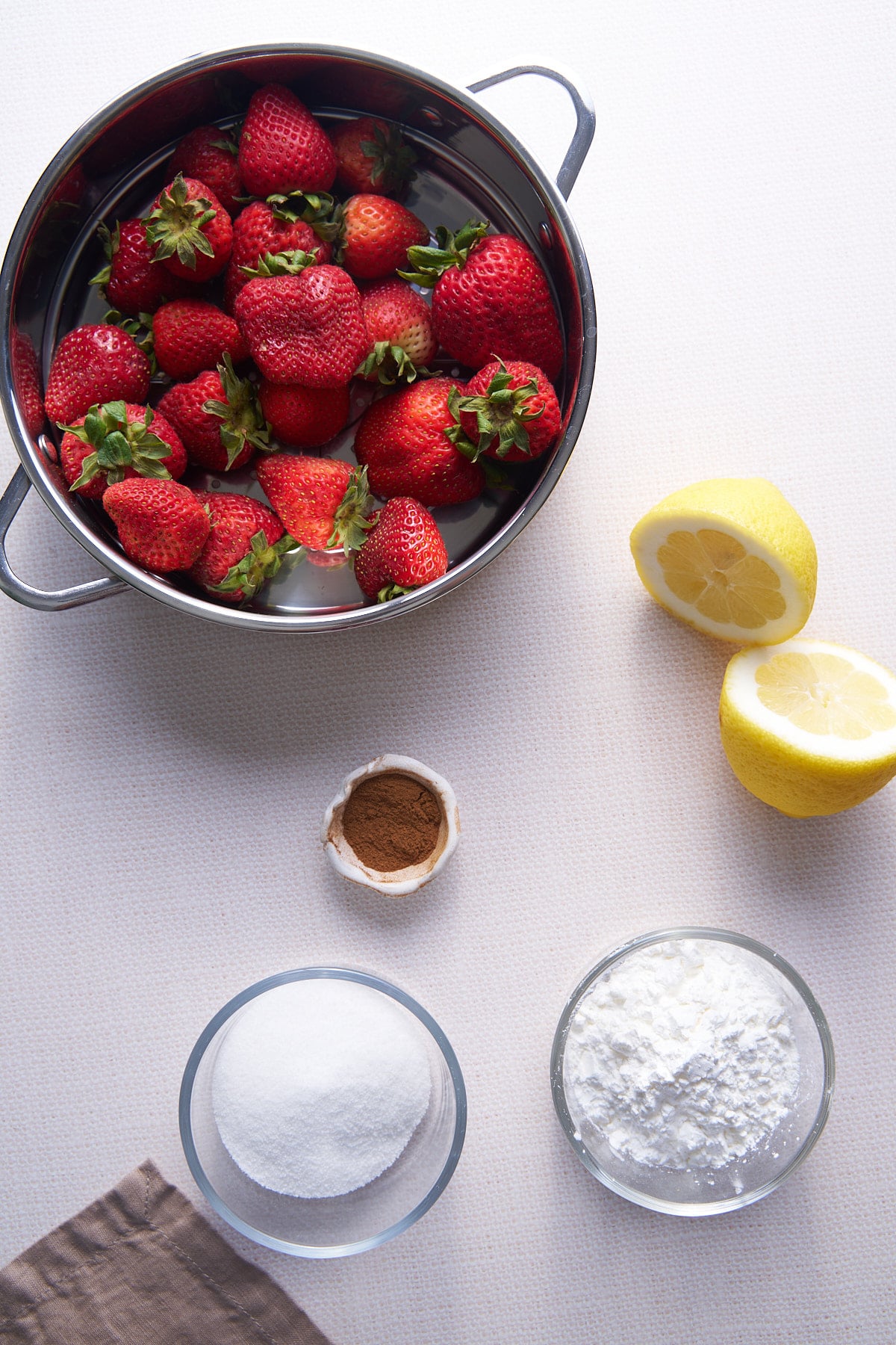 ingredients for a strawberry compote laid on table. 