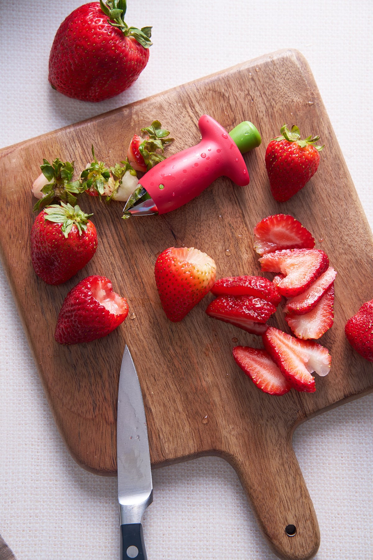 hulled strawberries on cutting board