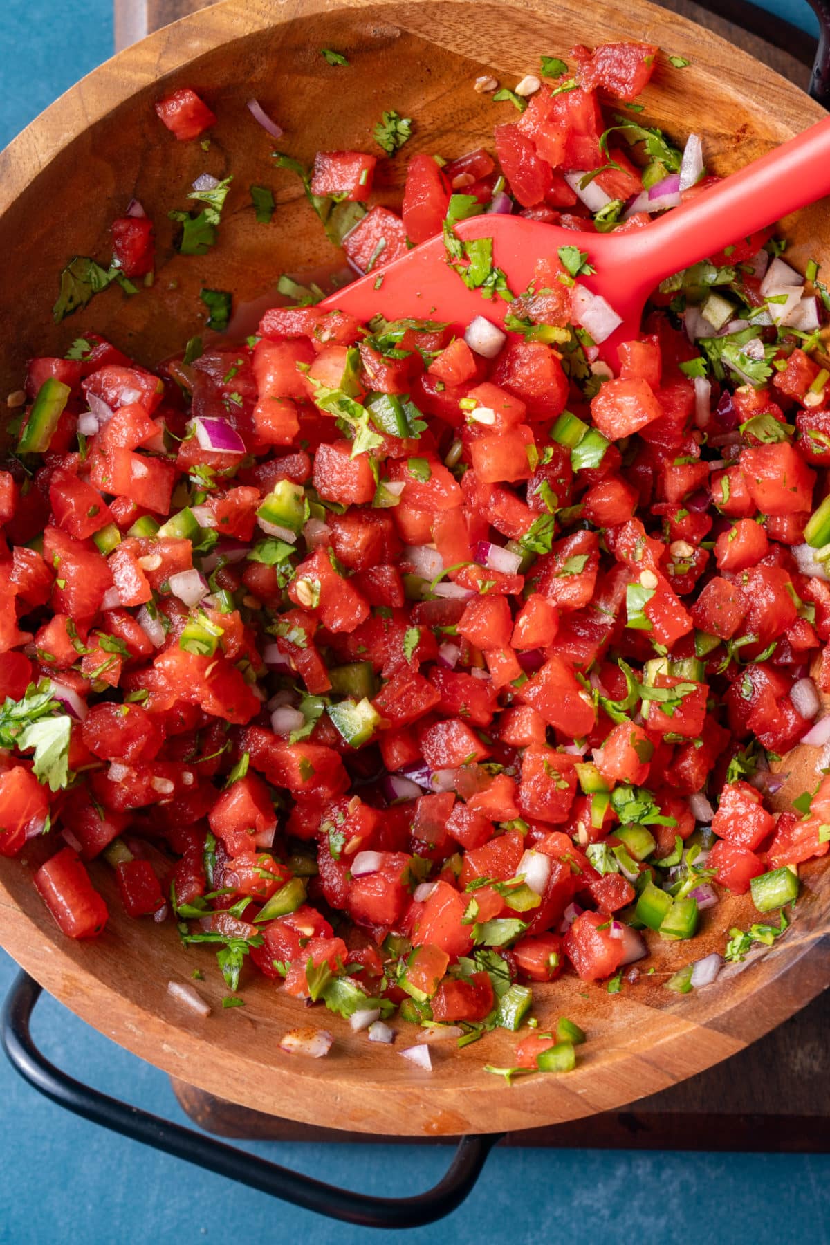 watermelon salsa ingredients in bowl, mixed, with spatula mixing it