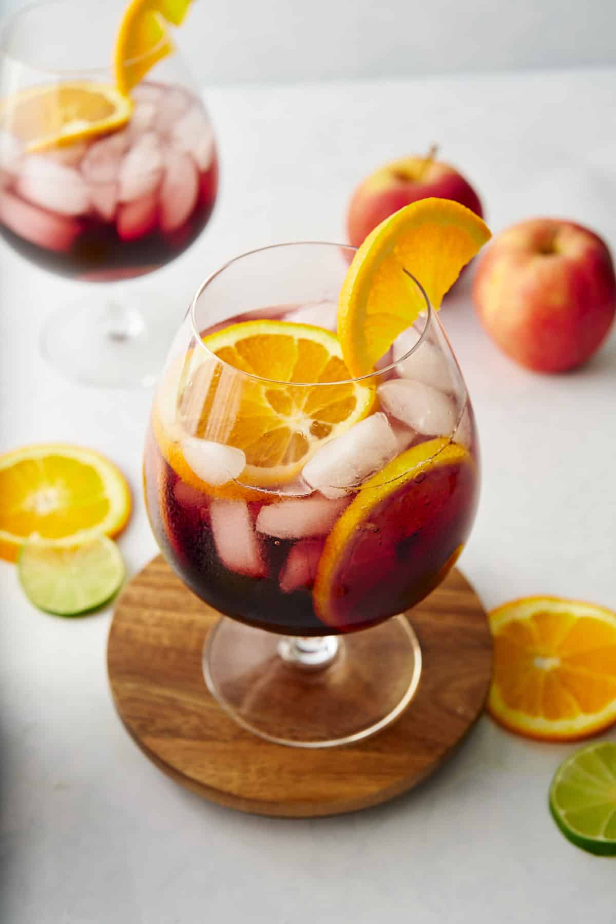 red sangria in glass with fruits in background