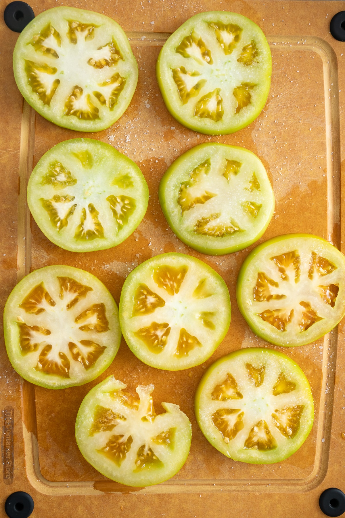 sliced tomatoes with cutting board with salt on them