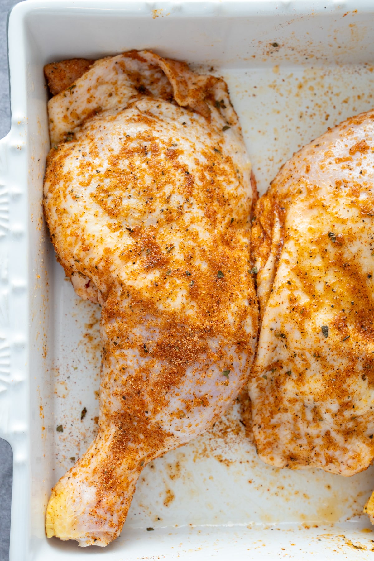 raw seasoned chicken in pan before baking