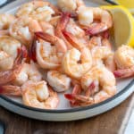 poached shrimp on a plate surrounded by lemons