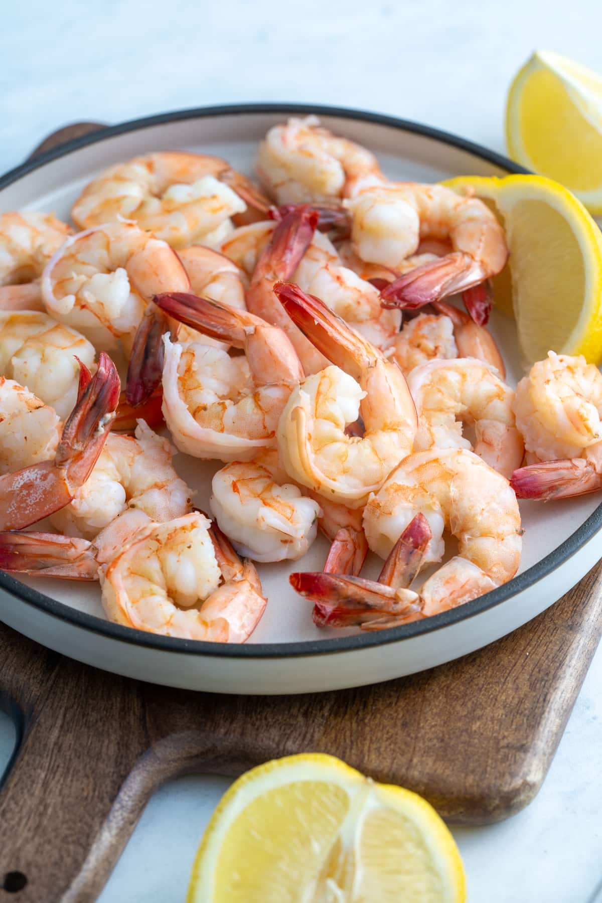 poached shrimp on a plate surrounded by lemons