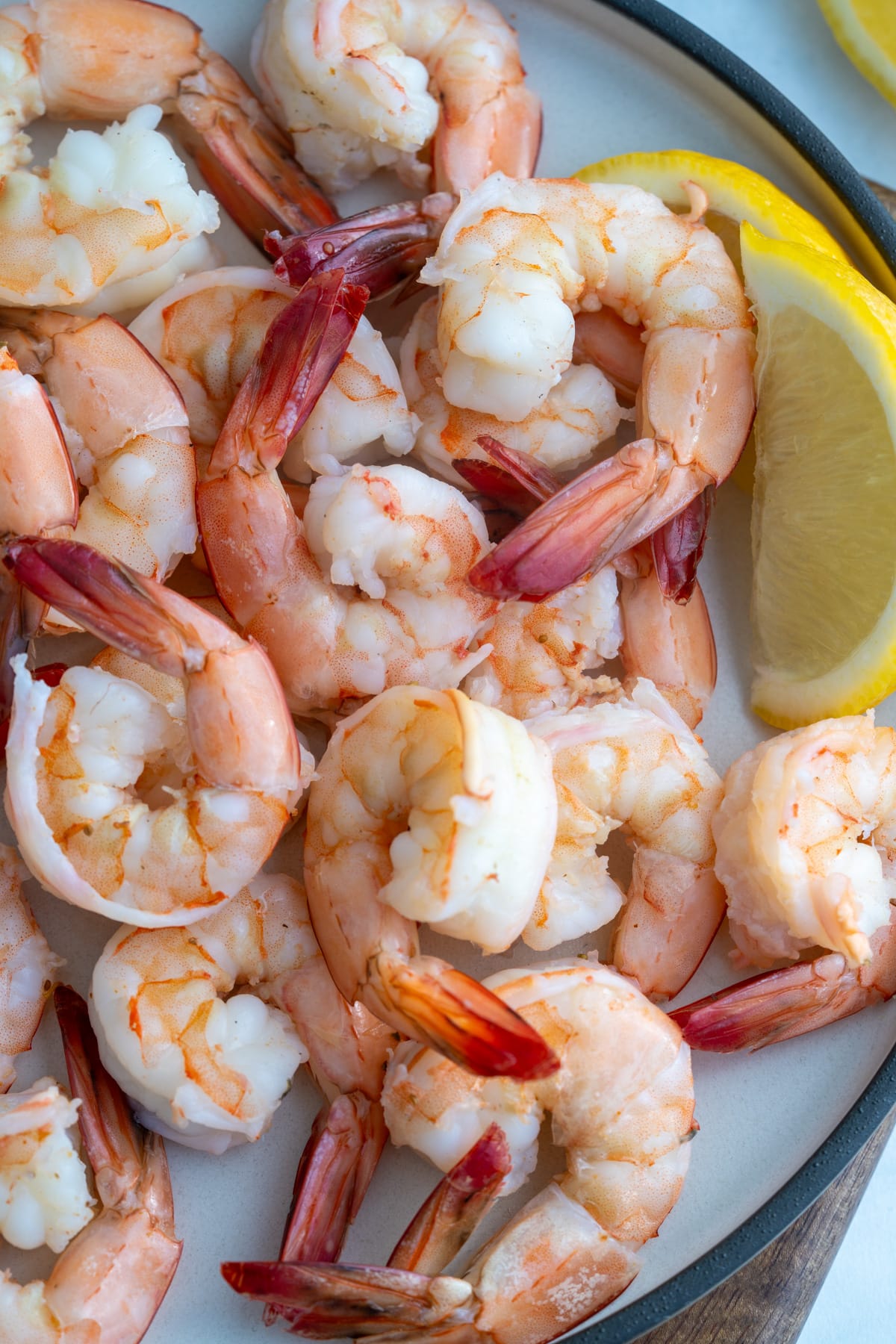 poached shrimp on plate with lemon on side