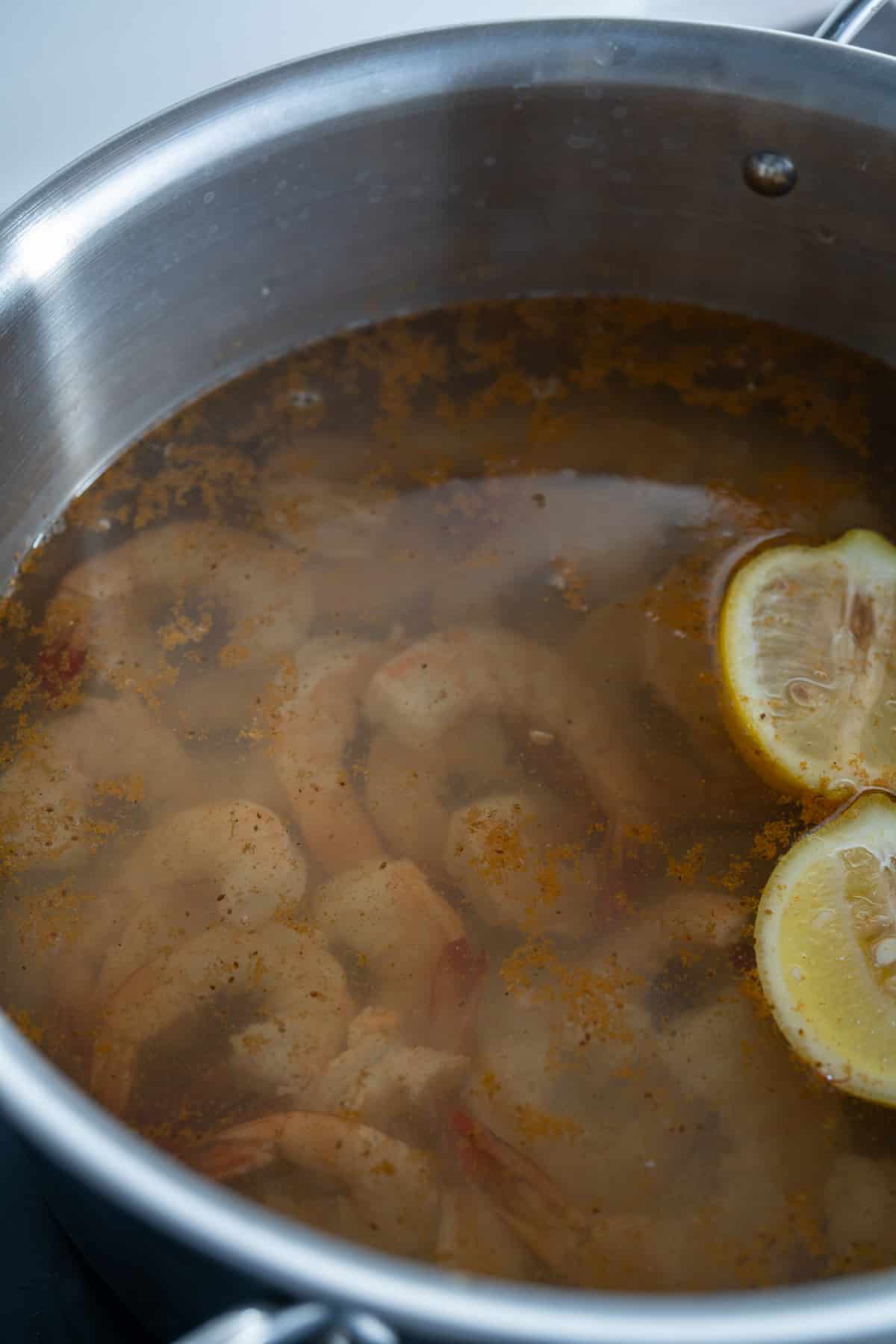 shrimp in poaching liquid in pot