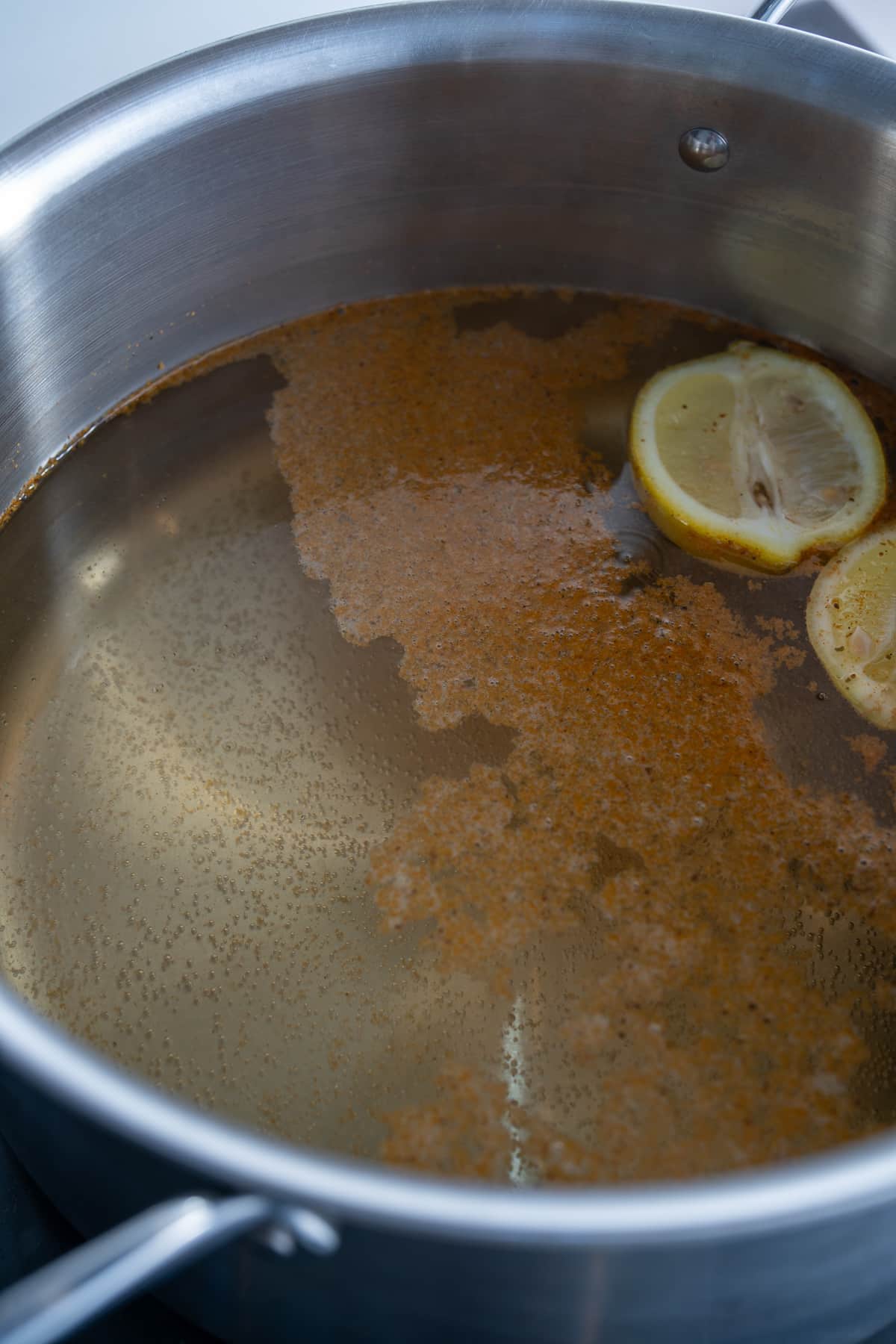 pot filled with water, old bay, and lime with small bubbles in pot