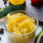 pickled watermelon rind in glass container with watermelon peel on side