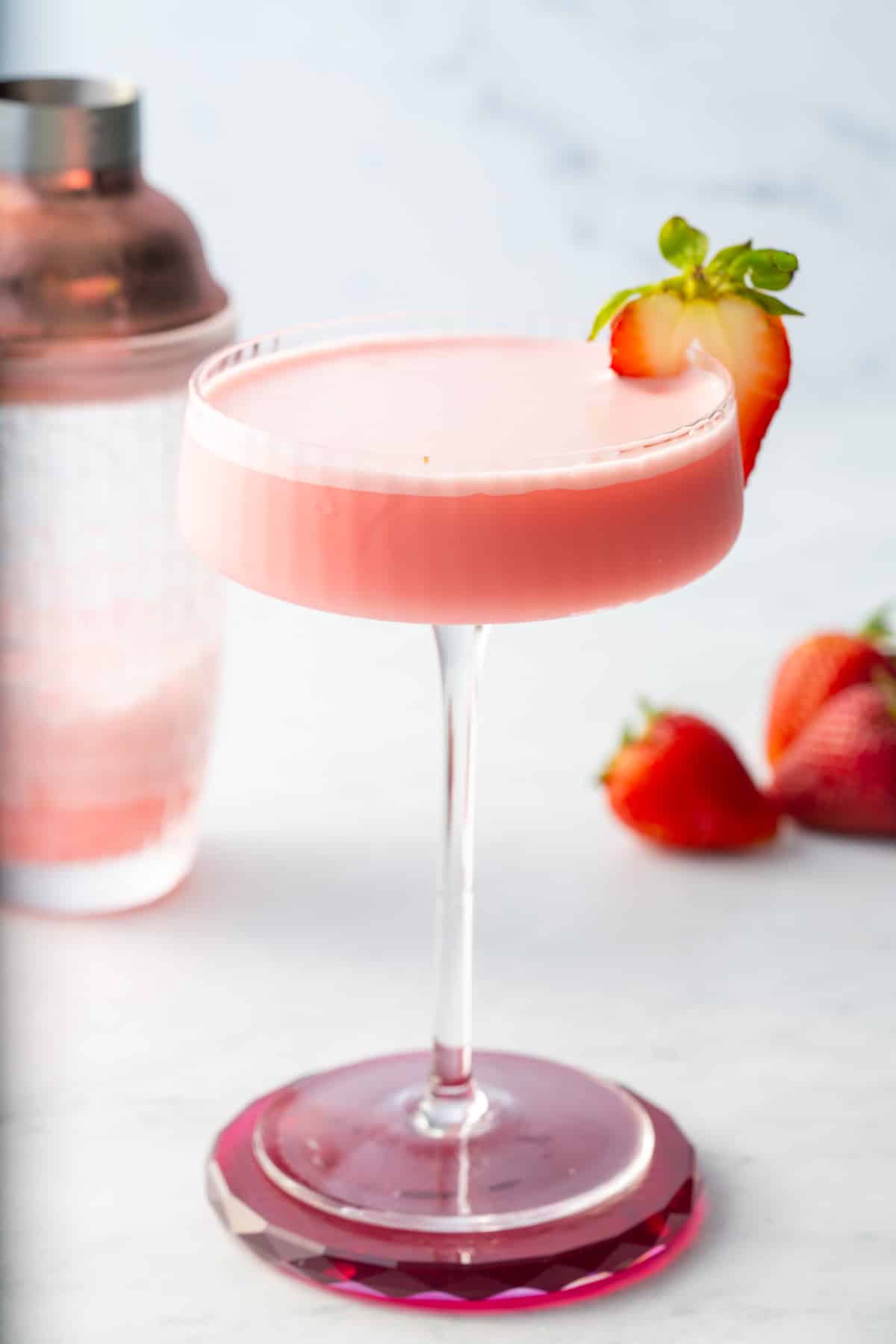 pink lady cocktail in glass with shaker in back