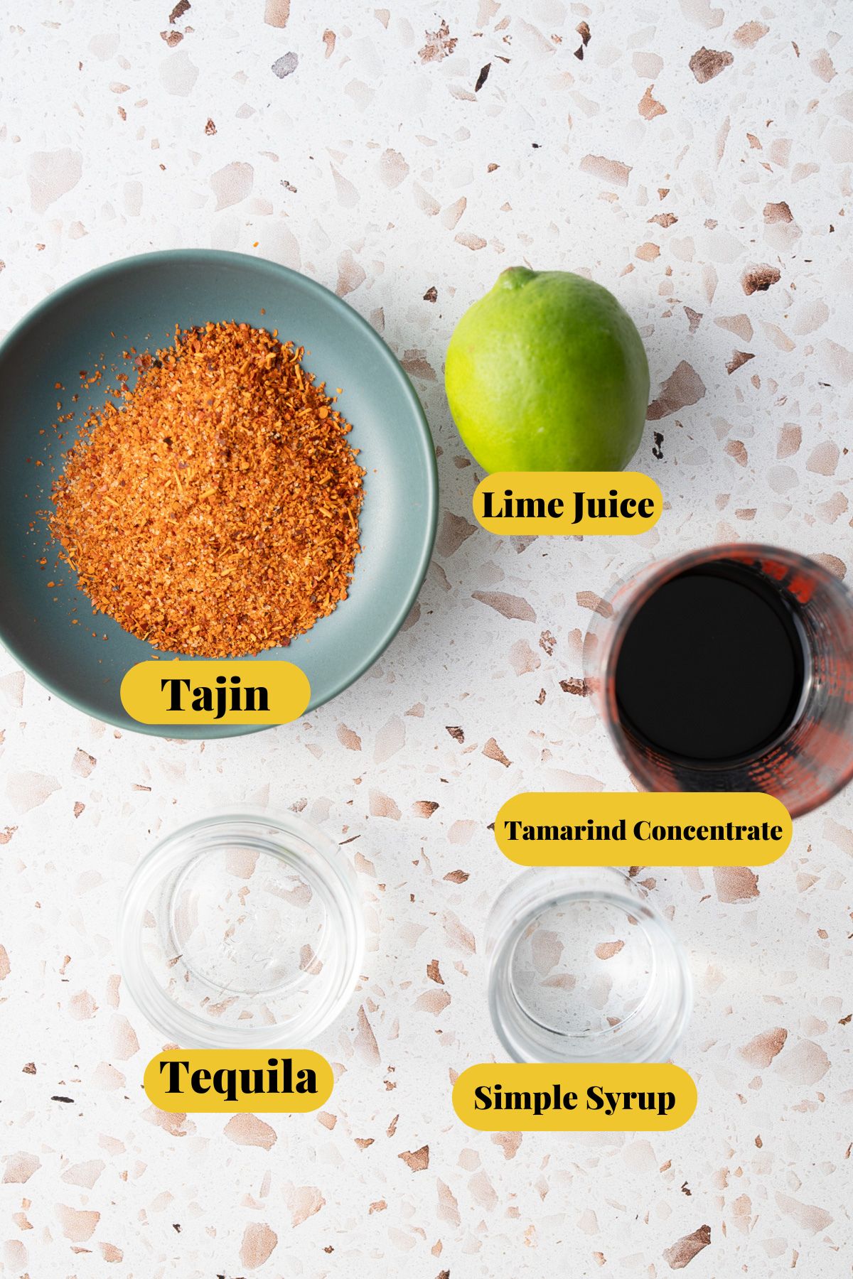 ingredients of tamarind margarita with labels showing which ingredient is which of takin, lime juice, tamarind concentrate, simple syrup, and tequila