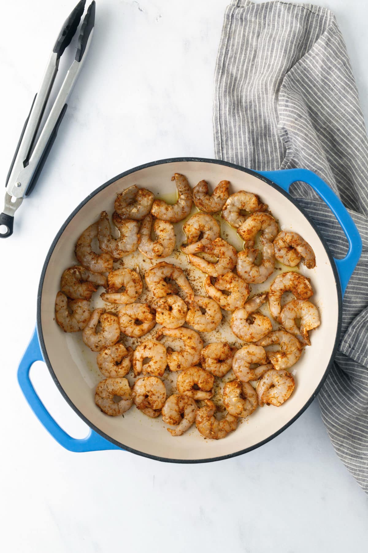 raw shrimp in skillet being cooked