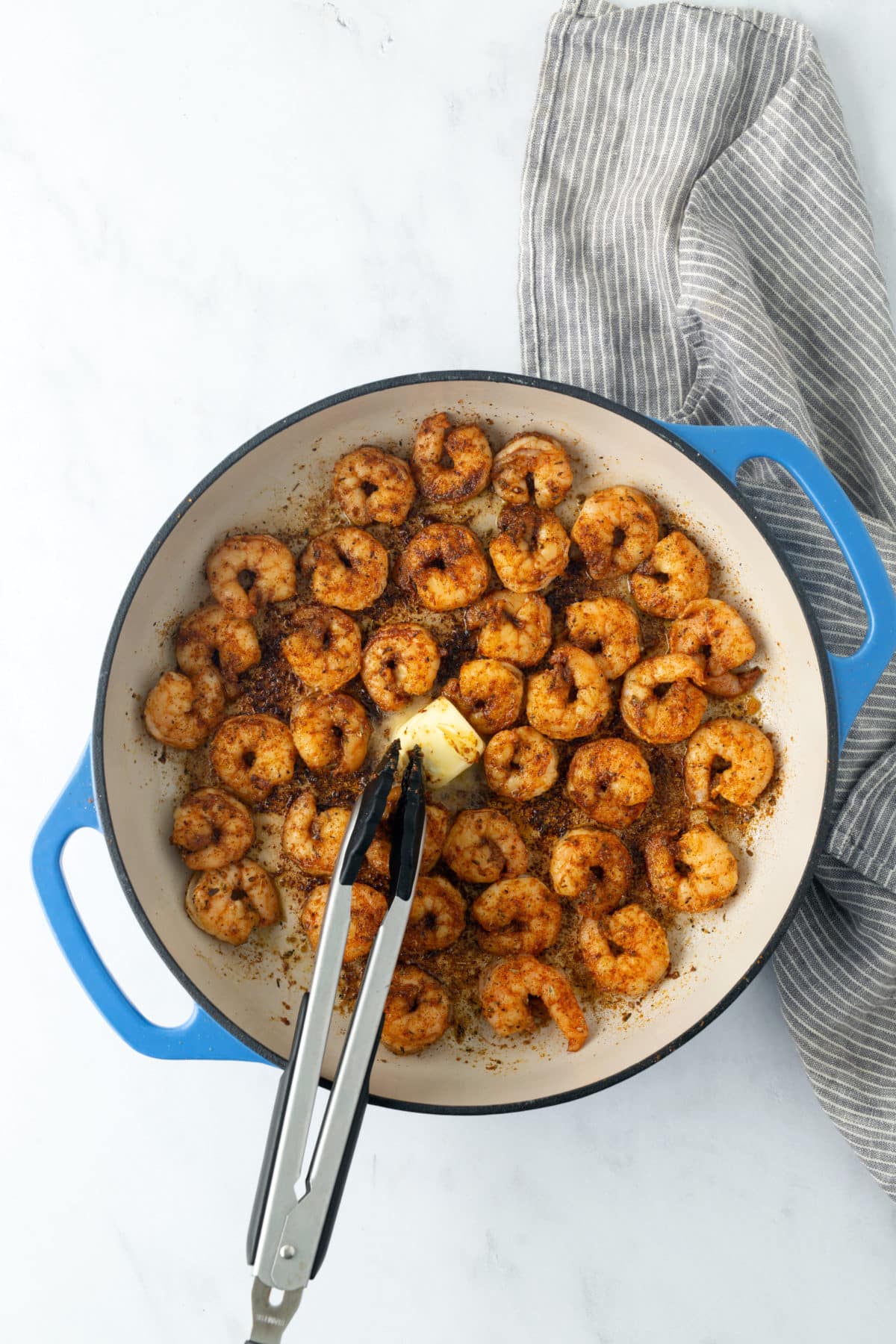 shrimp being cooked in skillet with butter