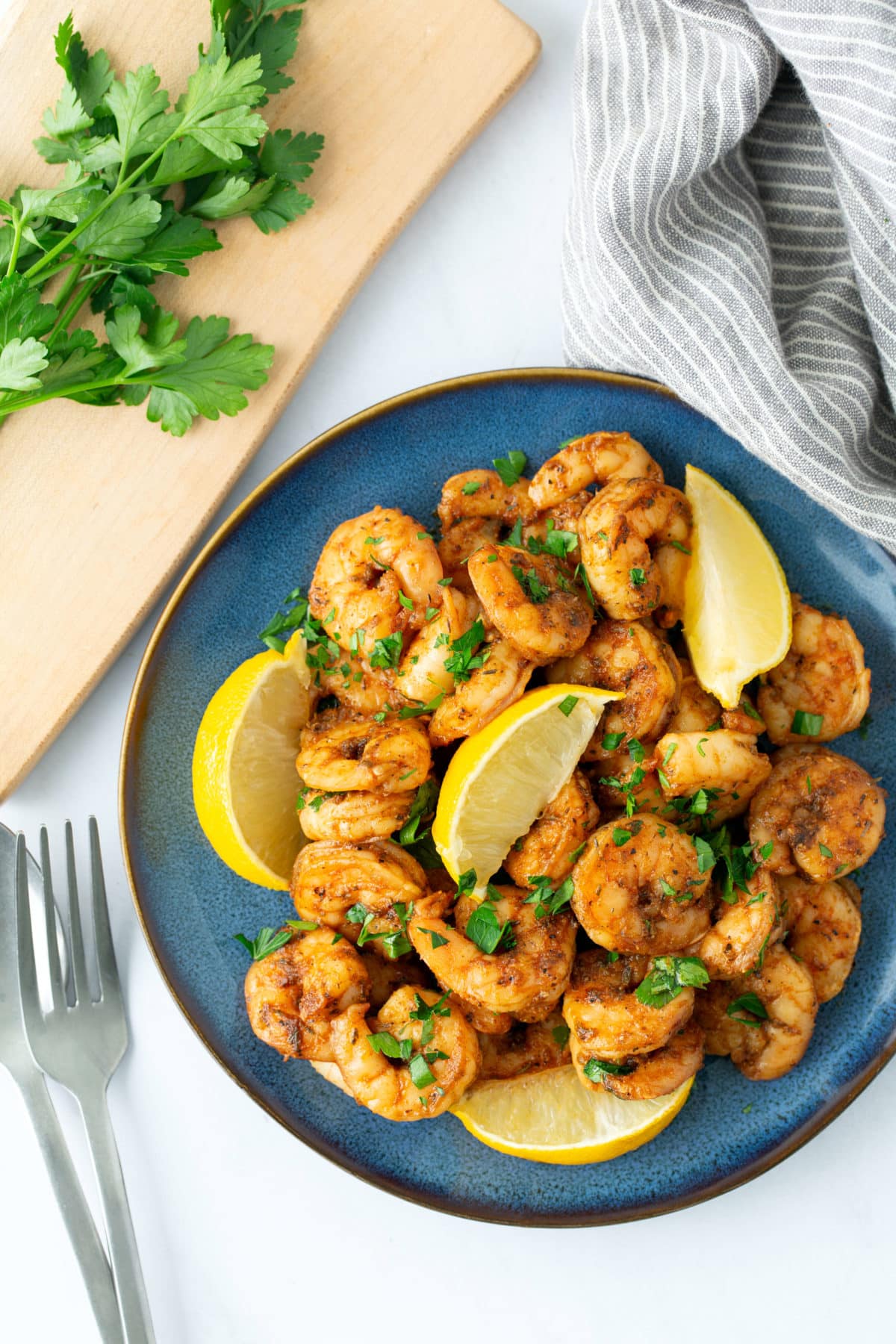 blackened shrimp on blue plate with fork on side