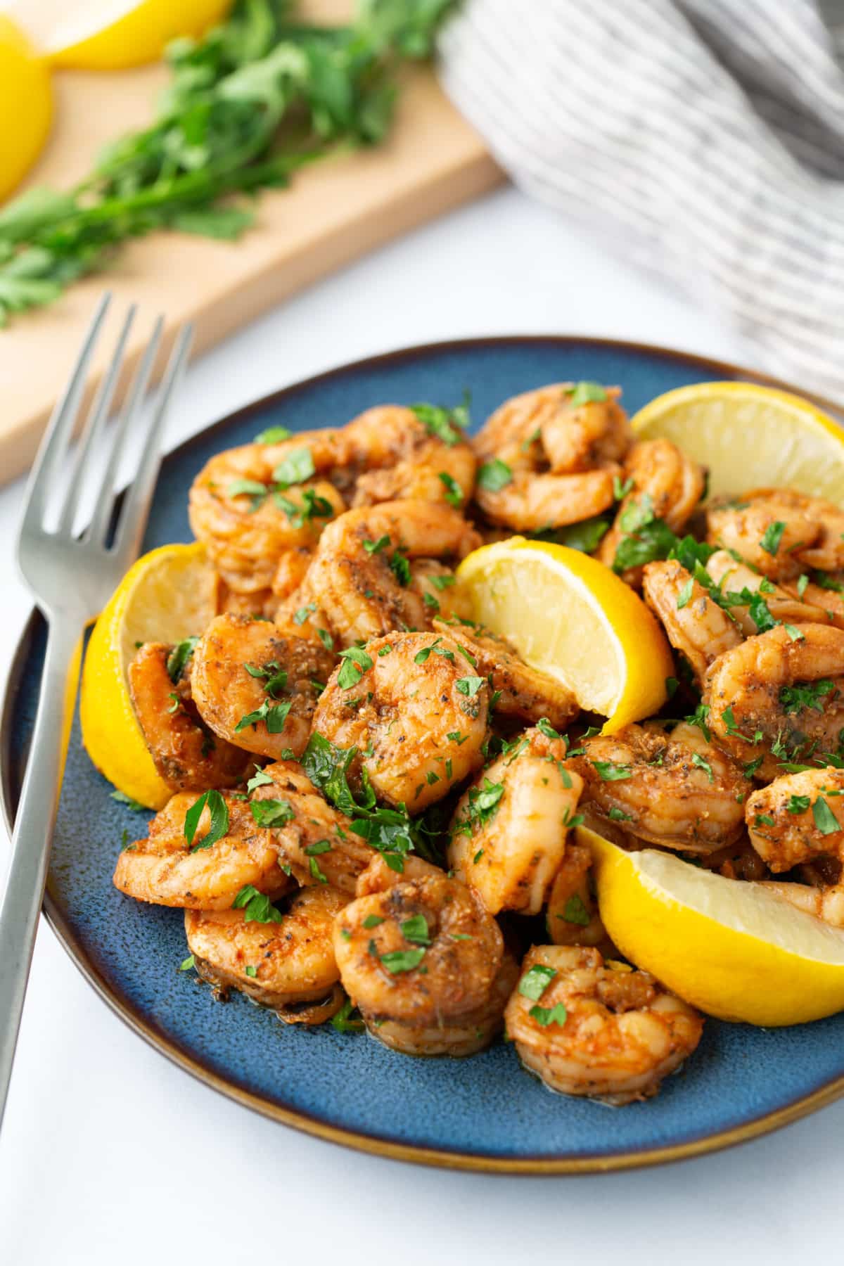 blackened shrimp on blue plate with fork on side