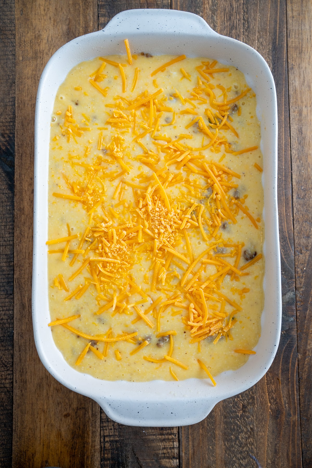 grits casserole with cheddar cheese on top before baking