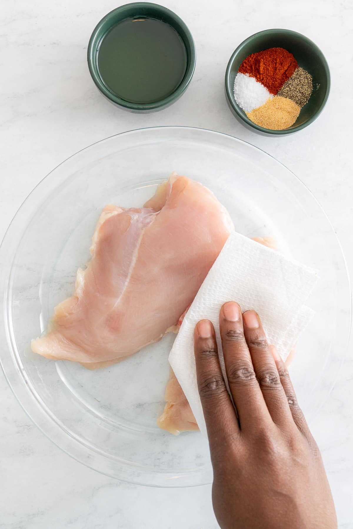 chicken breast being dried with paper towel