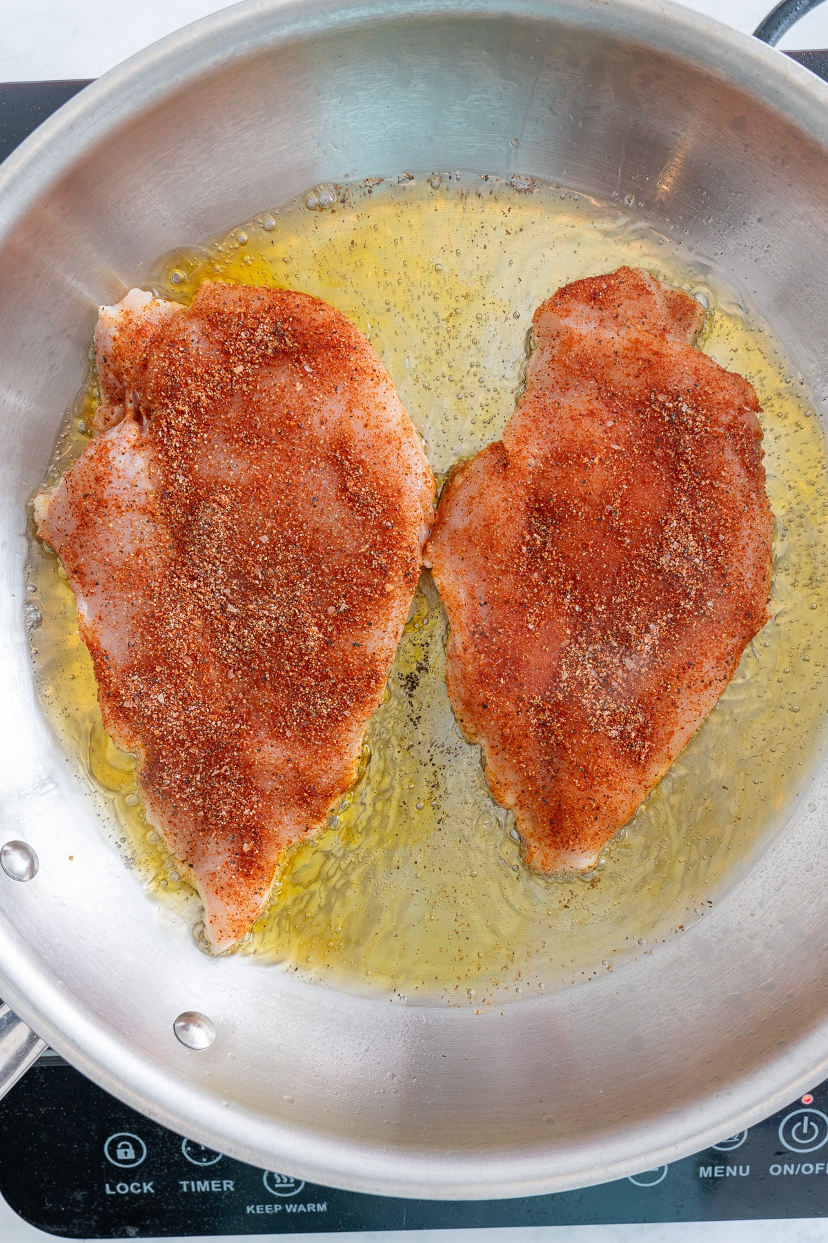 raw chicken breast in skillet