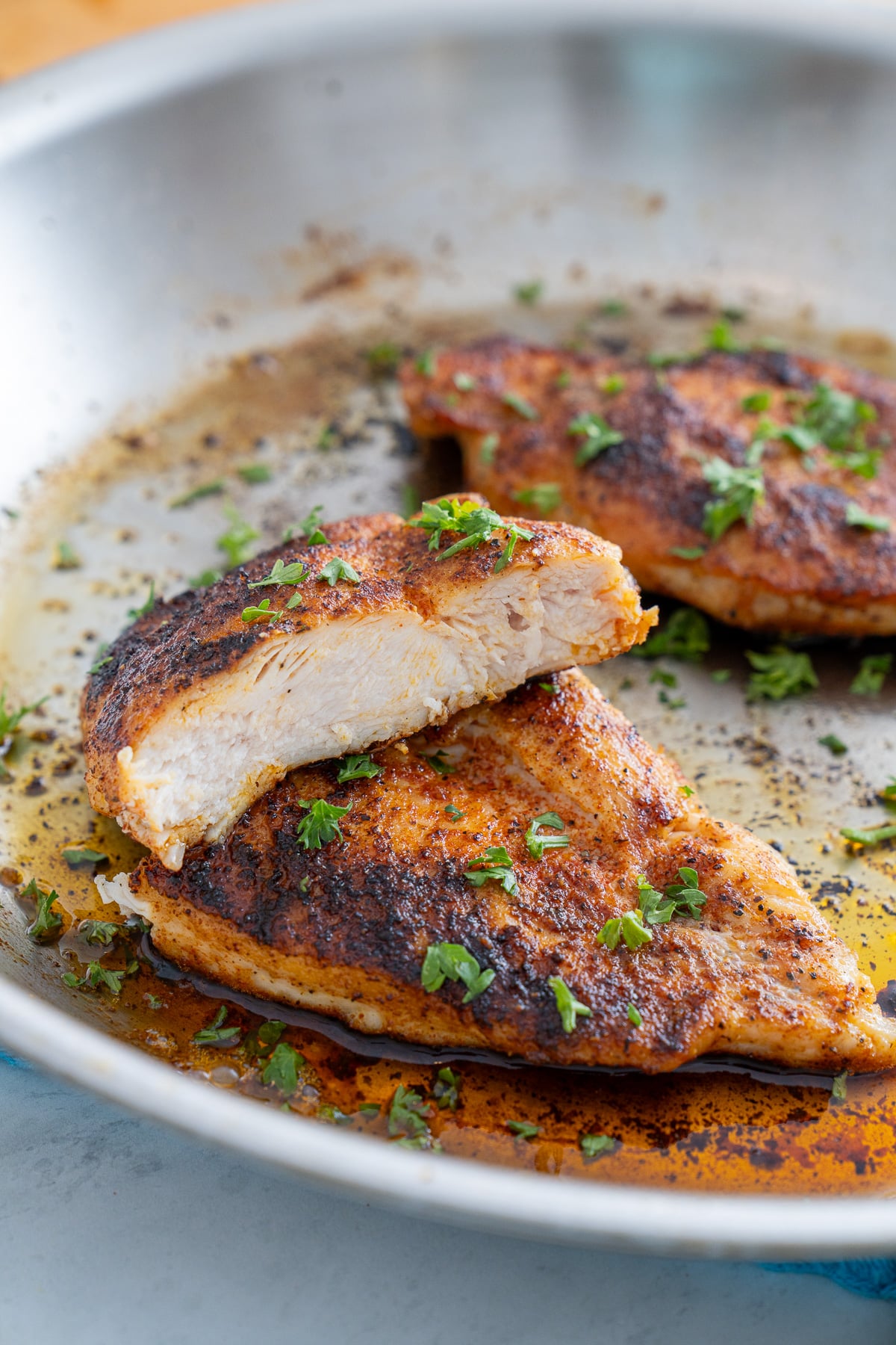 pan seared chicken breast in skillet after being sliced