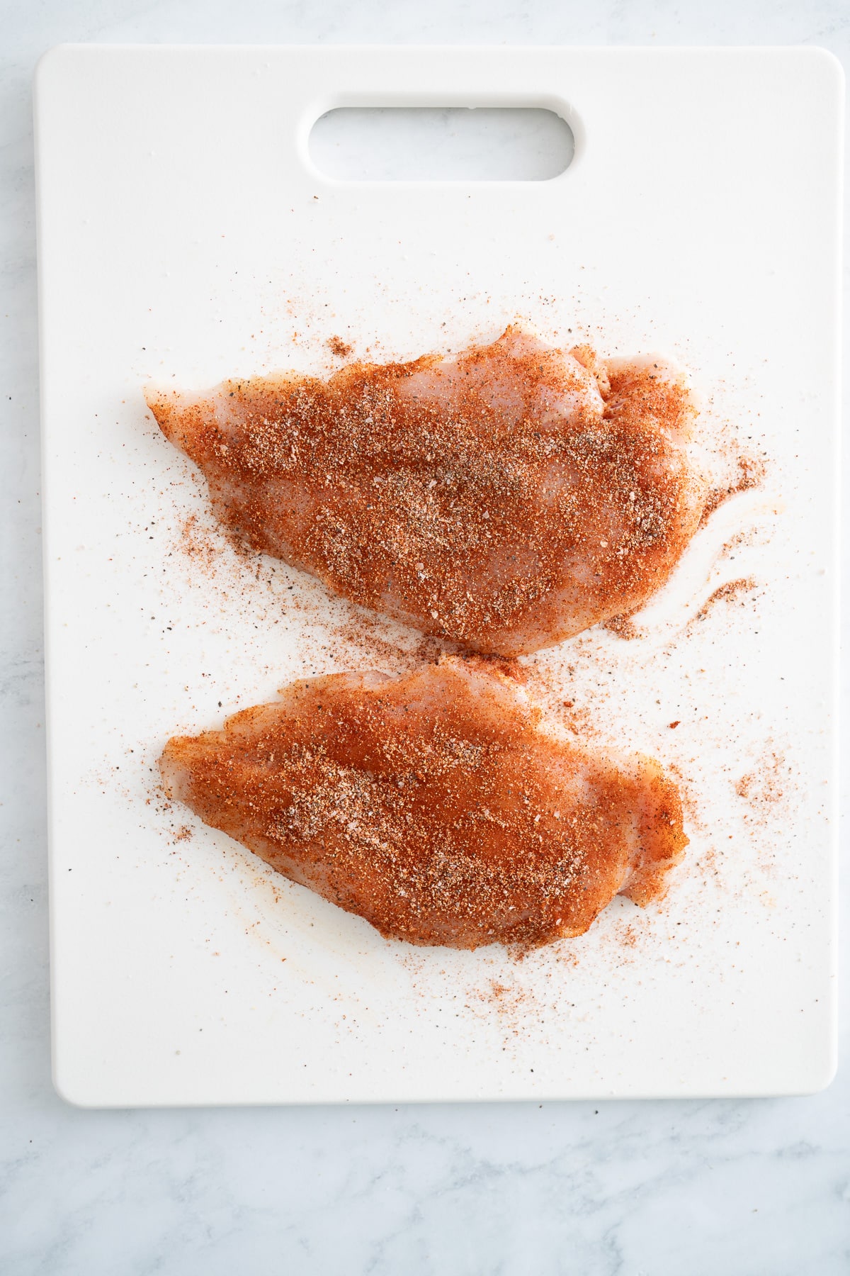 seasoned chicken on cutting board