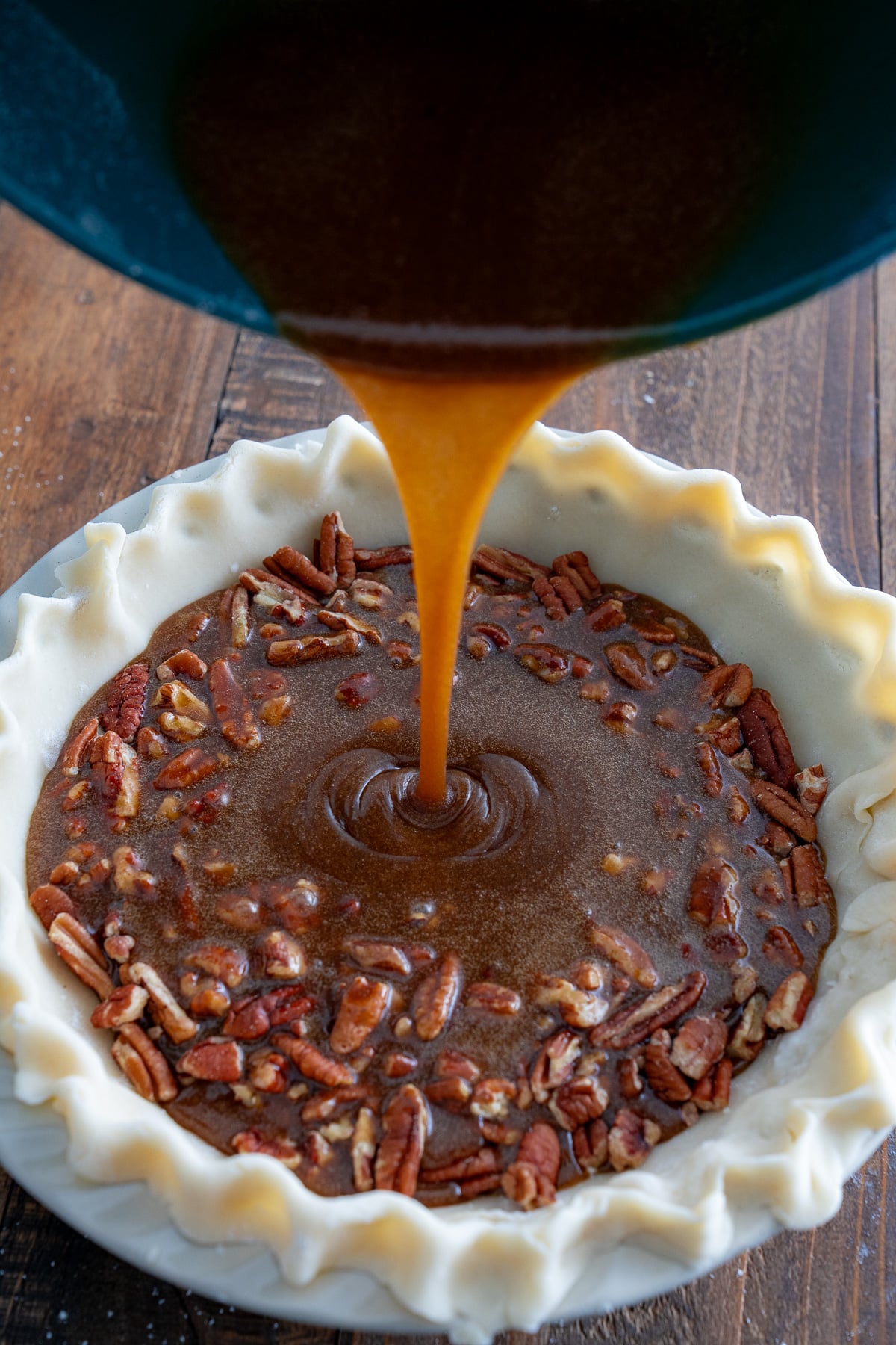 pecan pie filling being poured into crust