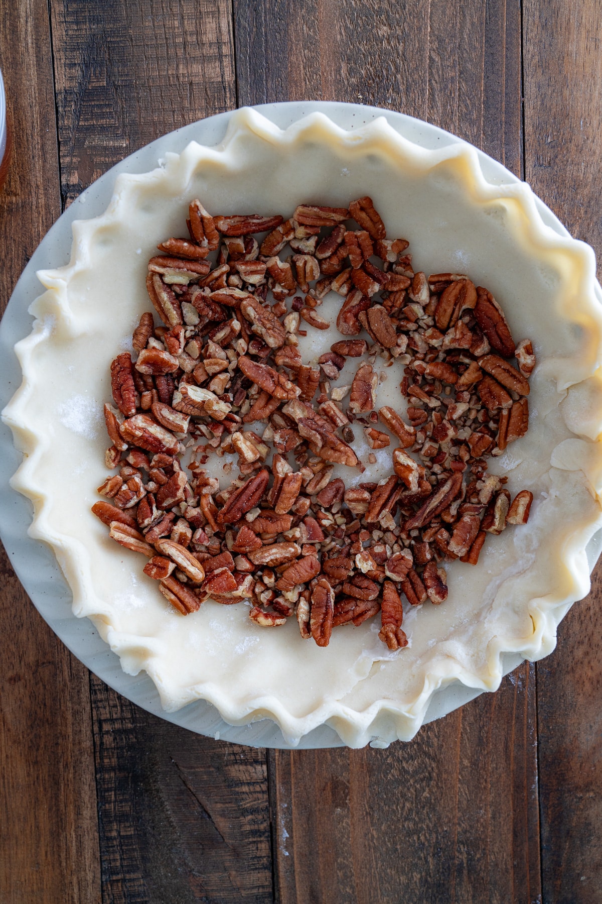 pecans in pie plate with the dough